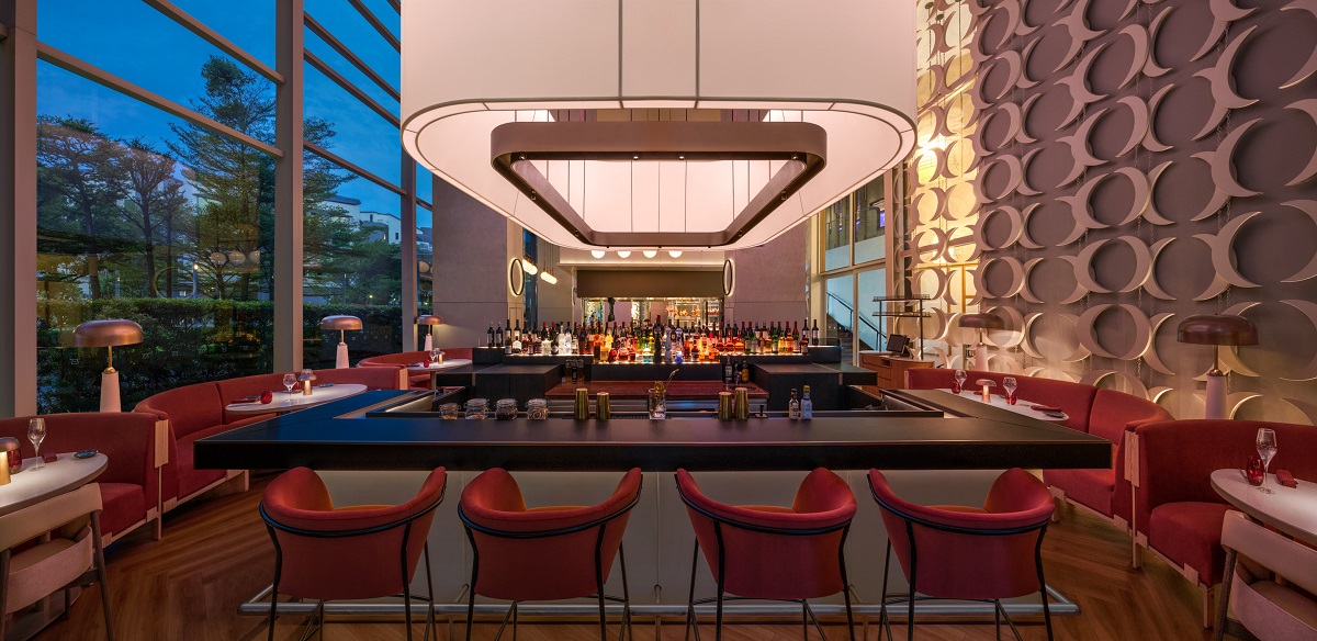 central curved bar with box light suspended above in same shape next to floor to ceiling windows in W SINGAPORE - SENTOSA COVE