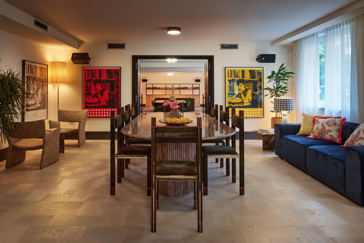 communal table in workspace at The Cover with art on either side of door leading into lounge
