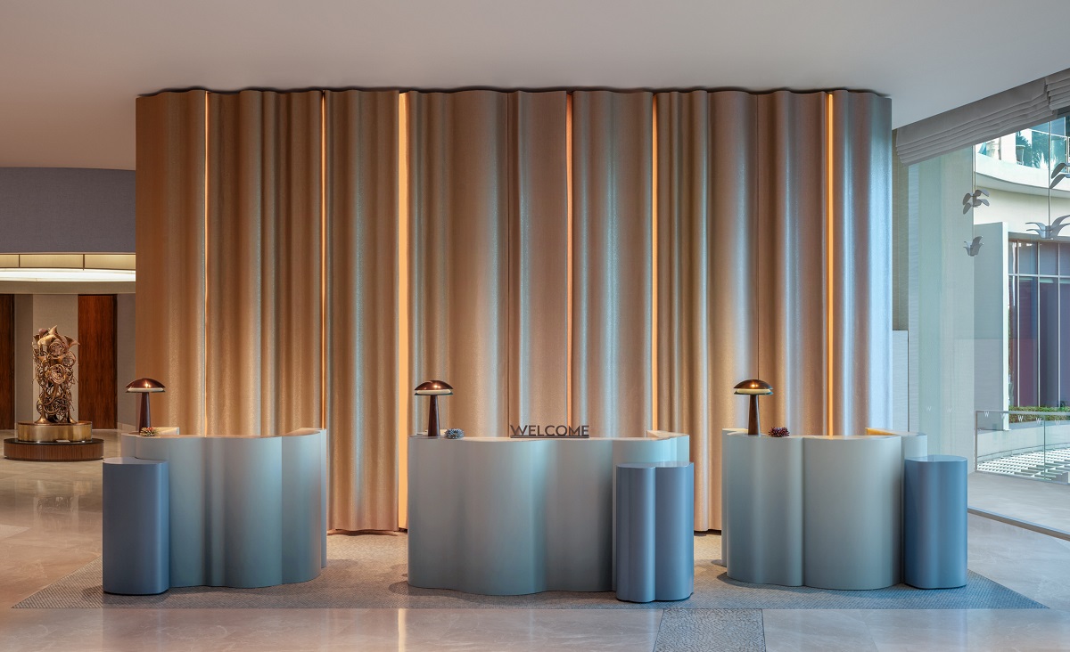 lobby with curved welcome desk and draped background in W SINGAPORE - SENTOSA COVE