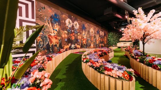entrance ramp to game venue with a green path lined with fake flowers and bright patterned wall coverings from Newmor