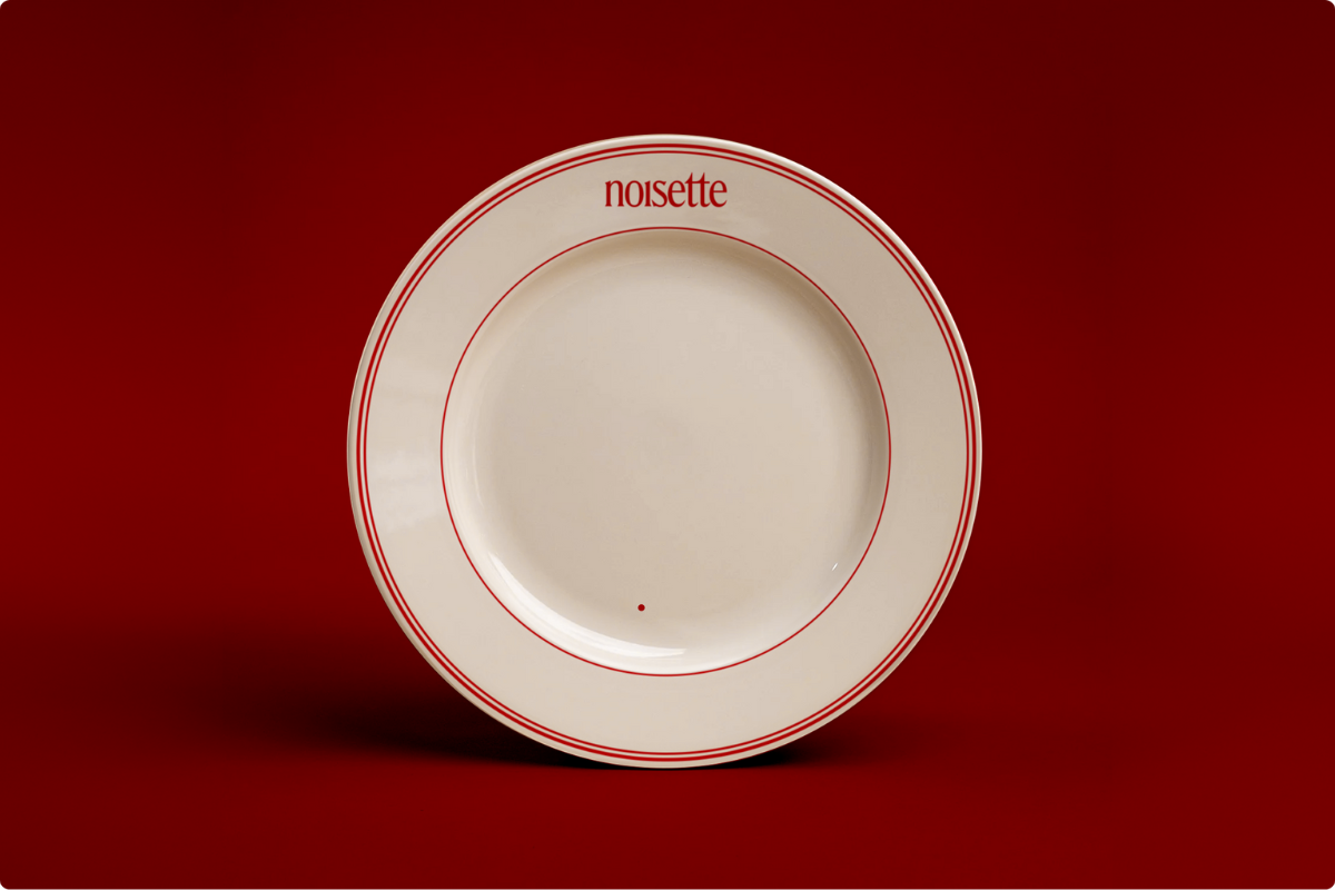 Red and white plate with Noisette branding for restaurant at Faubourg 21