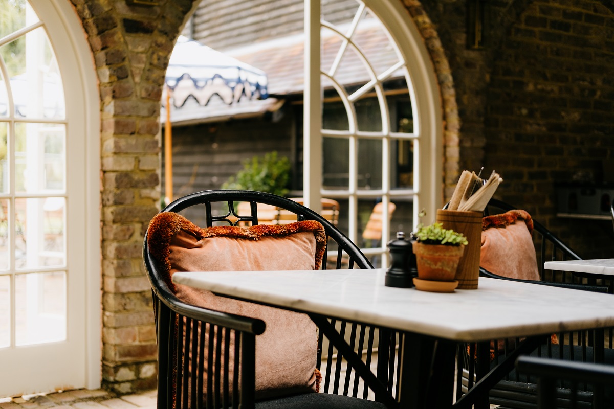 chair and table in front of arched stone window