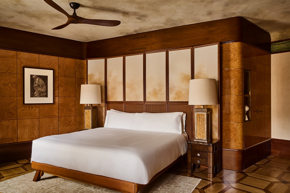 white bedlinen against wooden panelling with lamps on either side of the bed in the Orient Express suite master bedroom