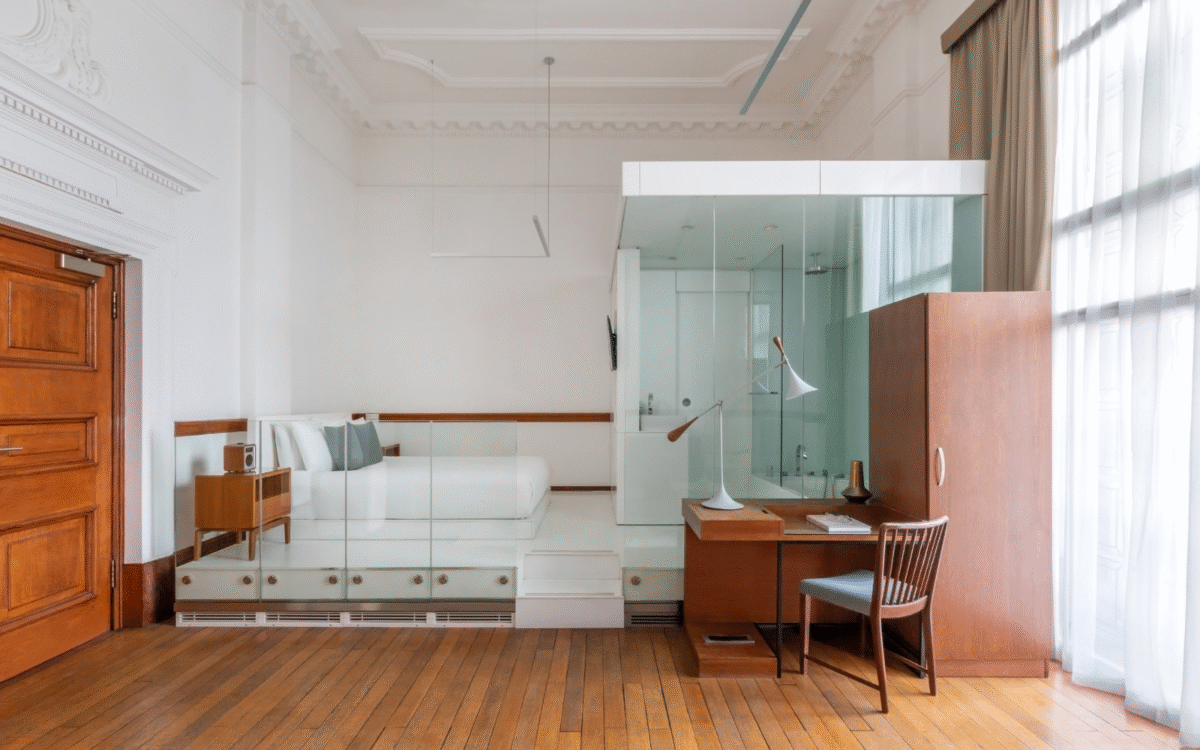 White and glass bedroom with mid century furniture at Town Hall Hotel