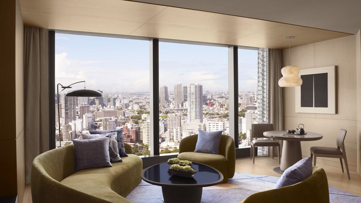 curved sofa and seating in front of floor to ceiling window with view over Tokyo