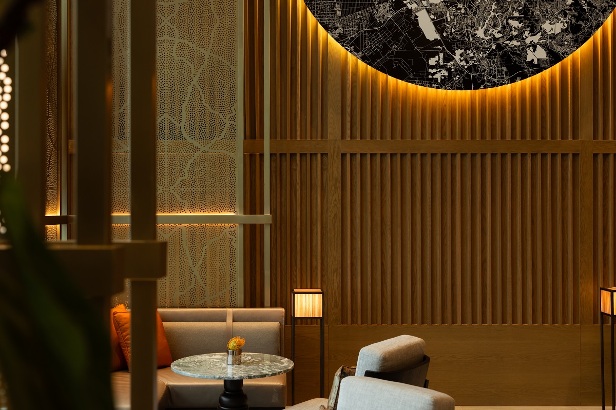 slatted wood surface detail with backlit focal pint above restaurant seating in Park Hyatt KL