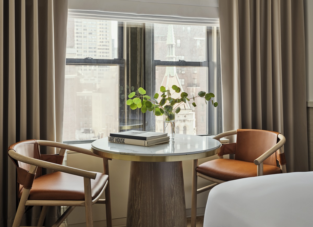 2 wooden and leather chairs at round table in guestroom window