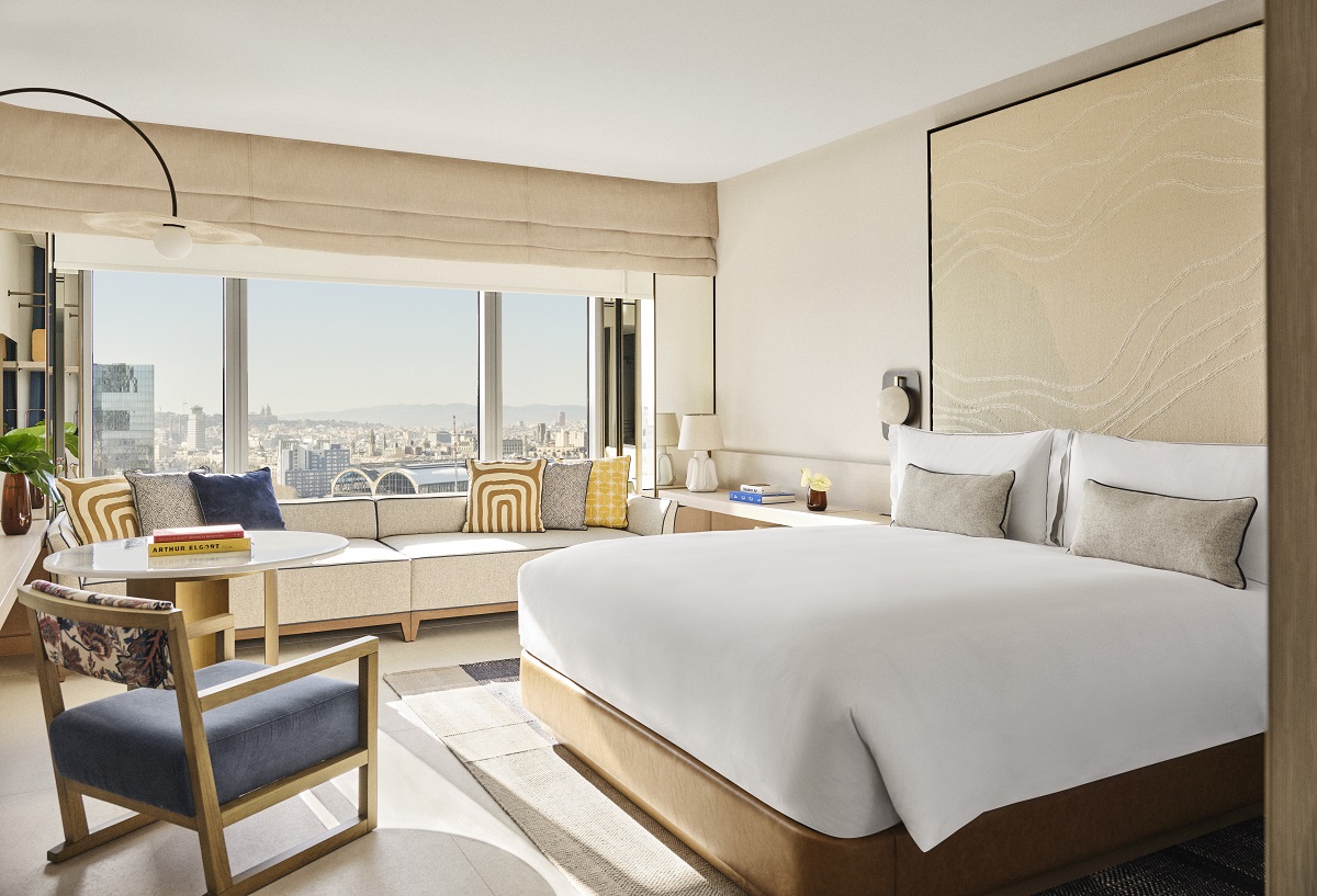 bed , chair and couch in hotel guestroom with panoramic view over Barcelona