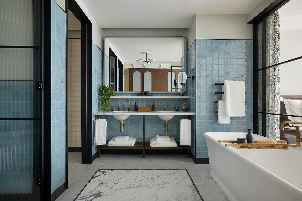 blue tiled bathroom with double vanity and freestanding bath