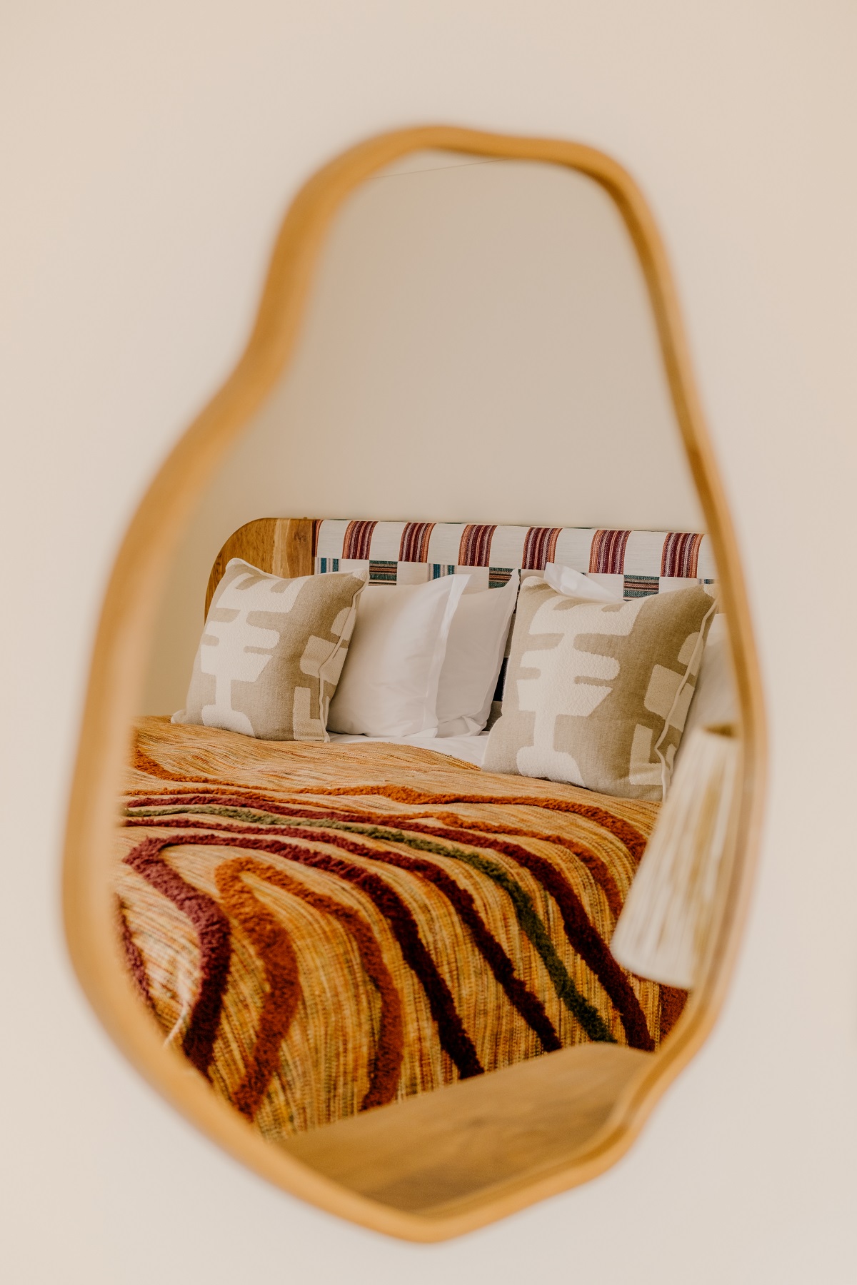 bed with striped woven throw reflected in mirror