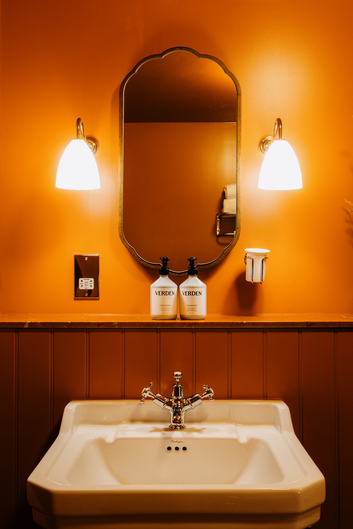 rust wooden panelling below saffron painted walls in the bathroom