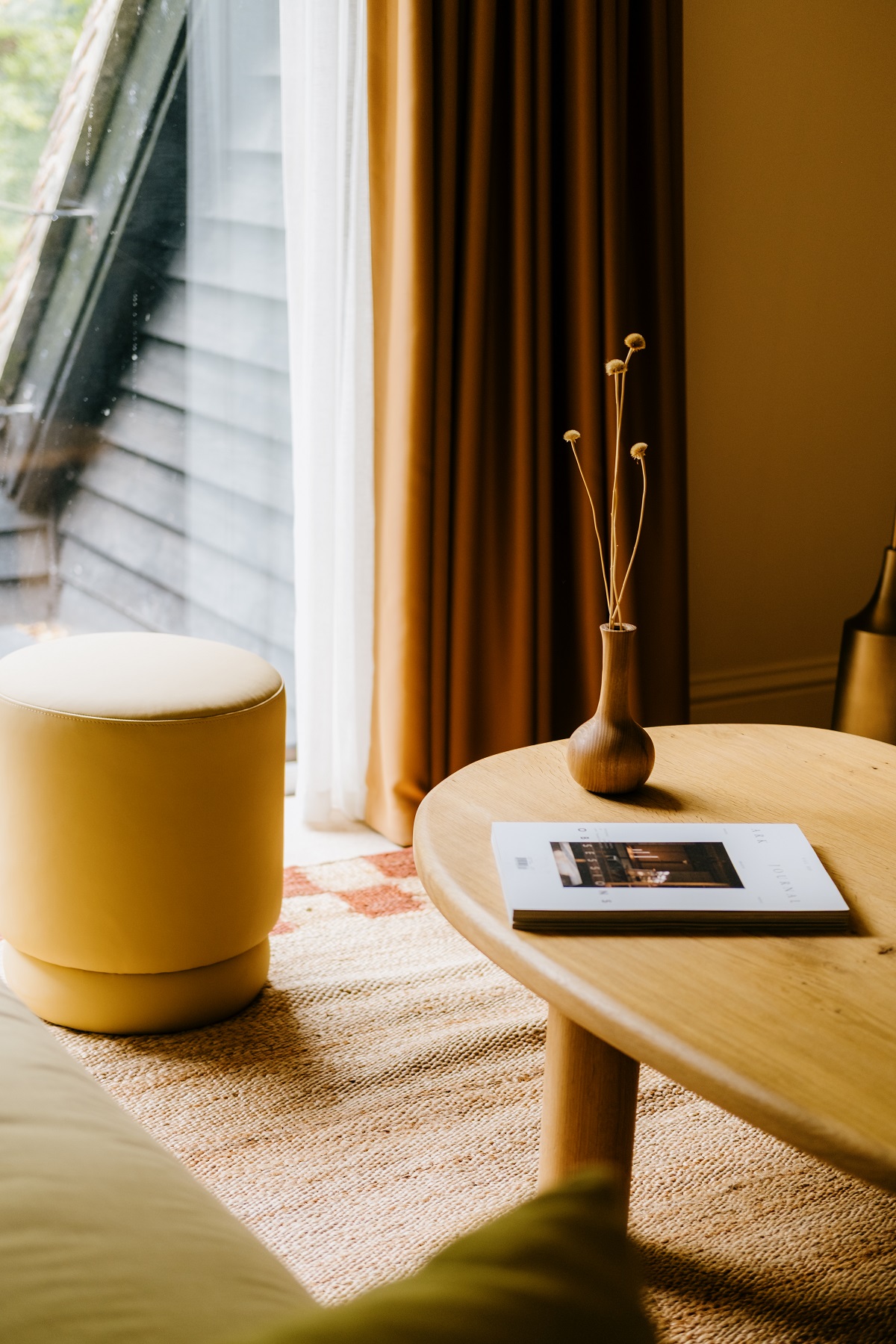 wooden table with vase and book in guestroom