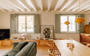 green sofa and light green shutters on windows in room with wooden table at The Verse hotel in Lisbon