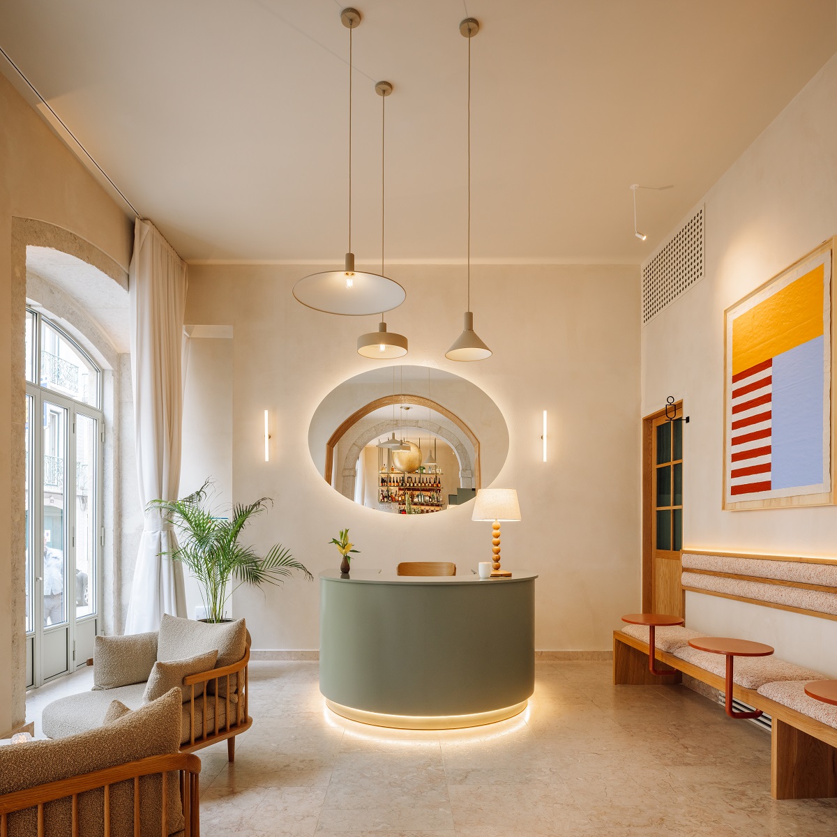 olive green reception desk in front of round mirror in lobby The Verse Lisbon