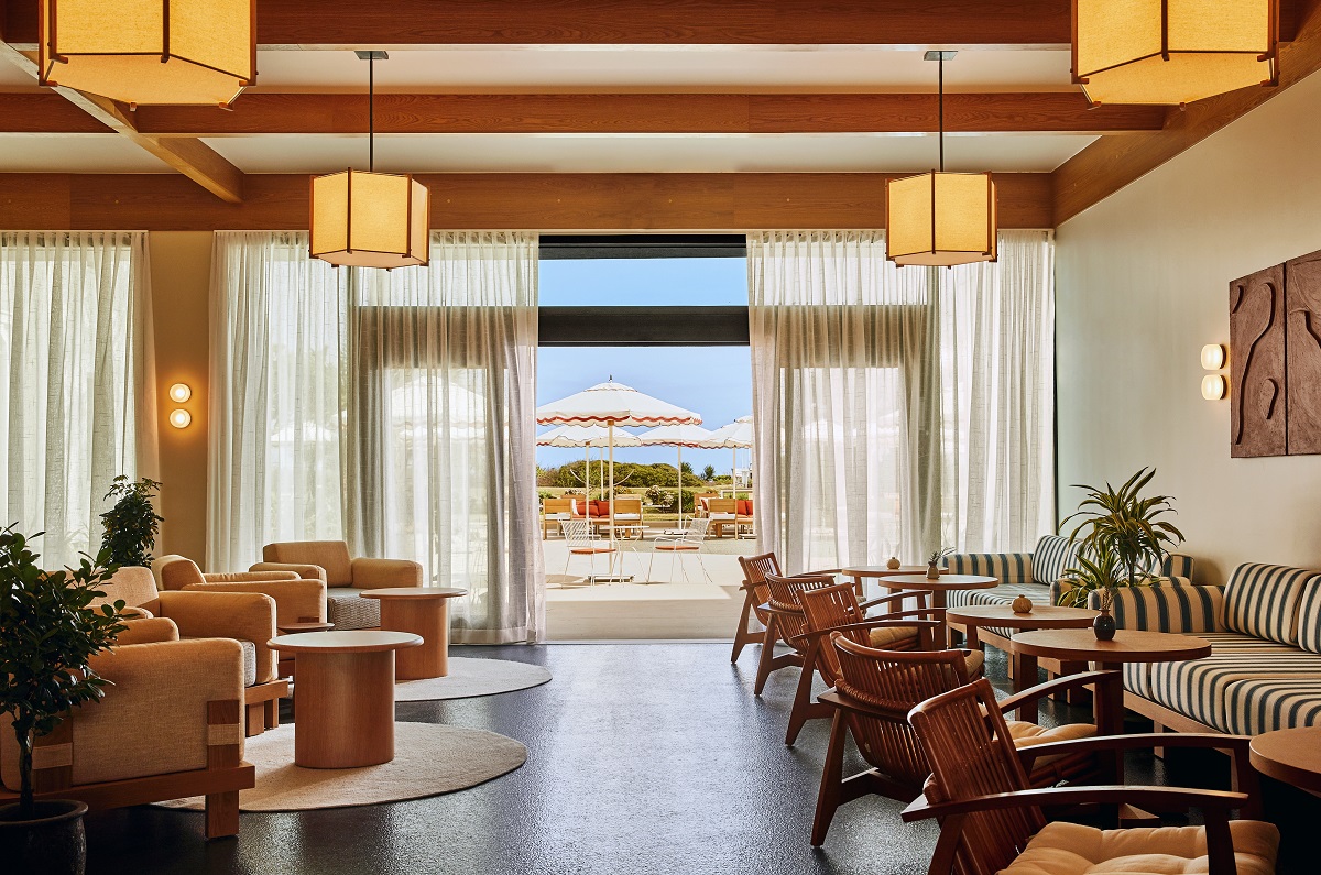 restaurant seating and couches with round tables all lead to view outdoors