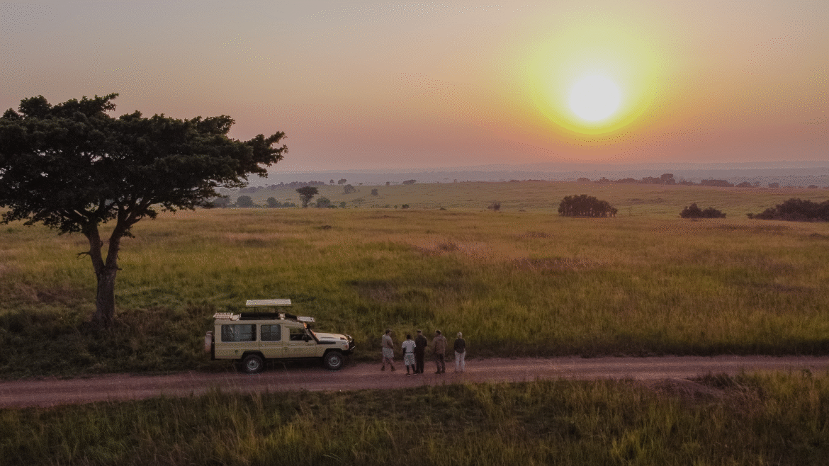 sunset over savannah in Uganda with thorn tree and landrover