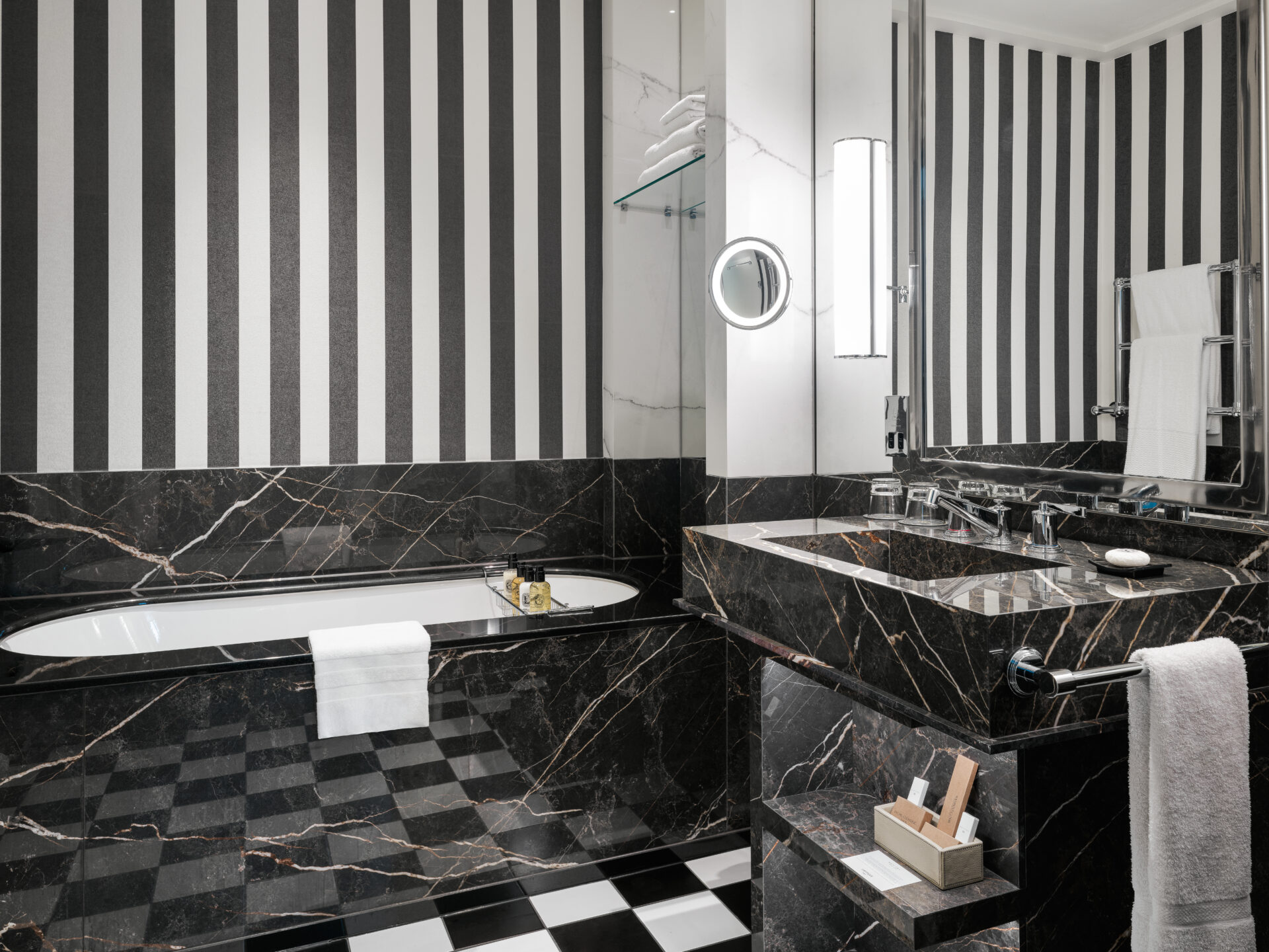 mirrored bathroom with black and white stripe walls and chequerboard flooring