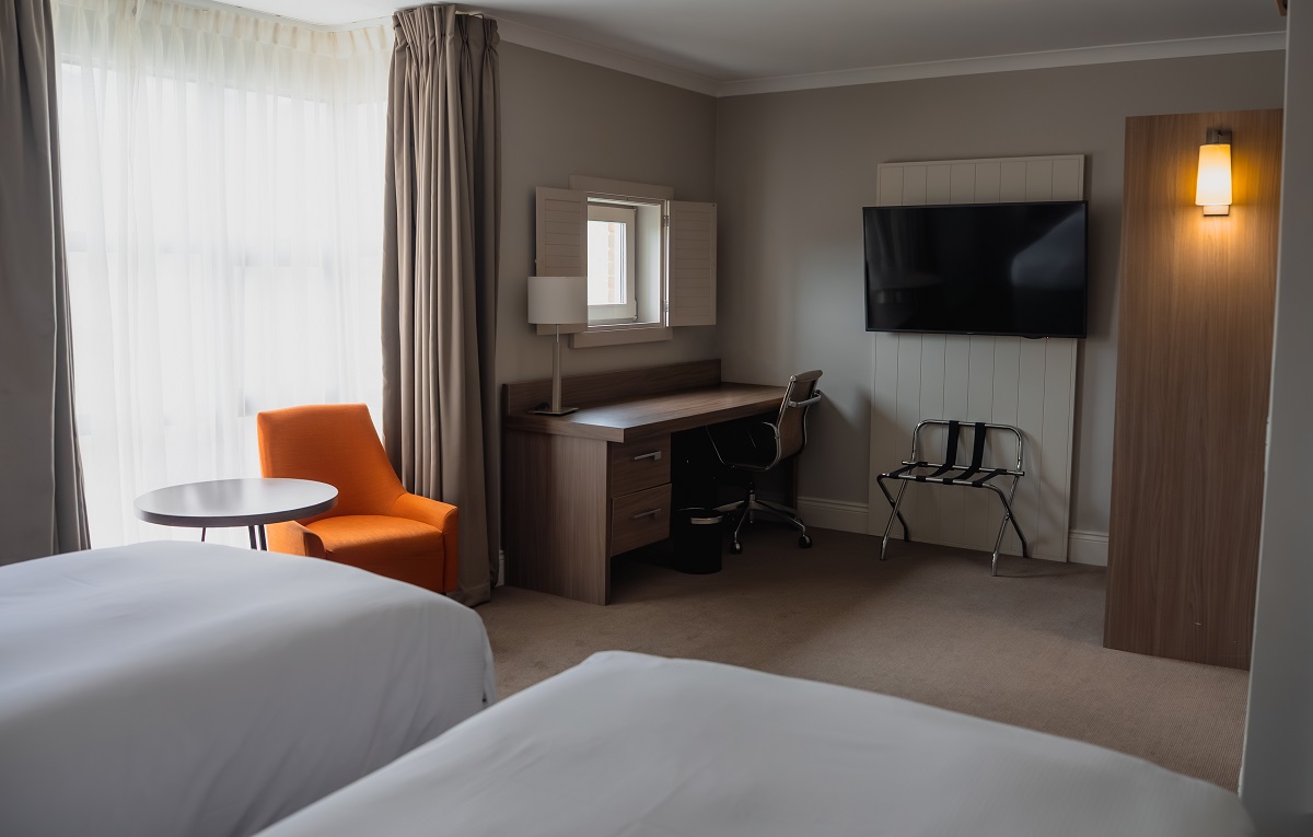 single beds and orange chair in window in ao hostels london docklands