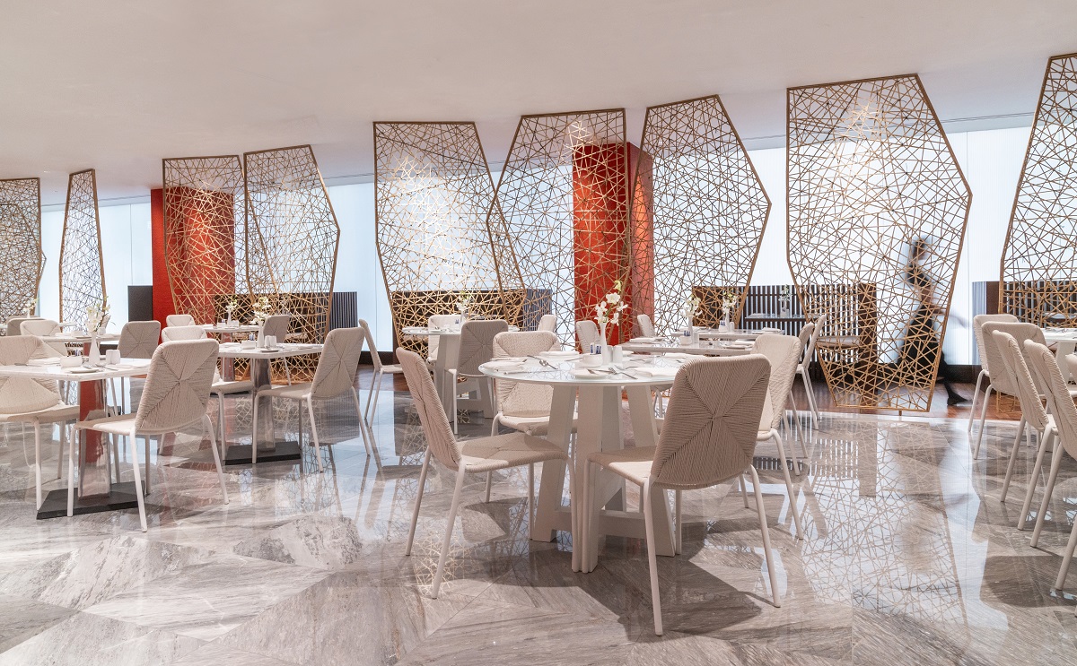 light filled restaurant design with wicker room dividers and orange panels
