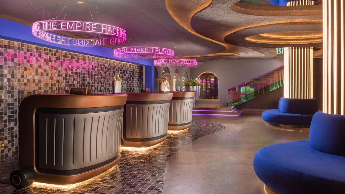 blue couches, neon lighting and reception desks in nhow Roma lobby