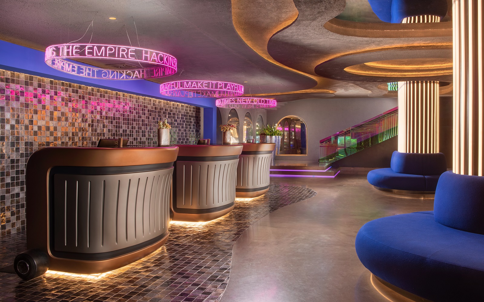 blue couches, neon lighting and reception desks in nhow Roma lobby