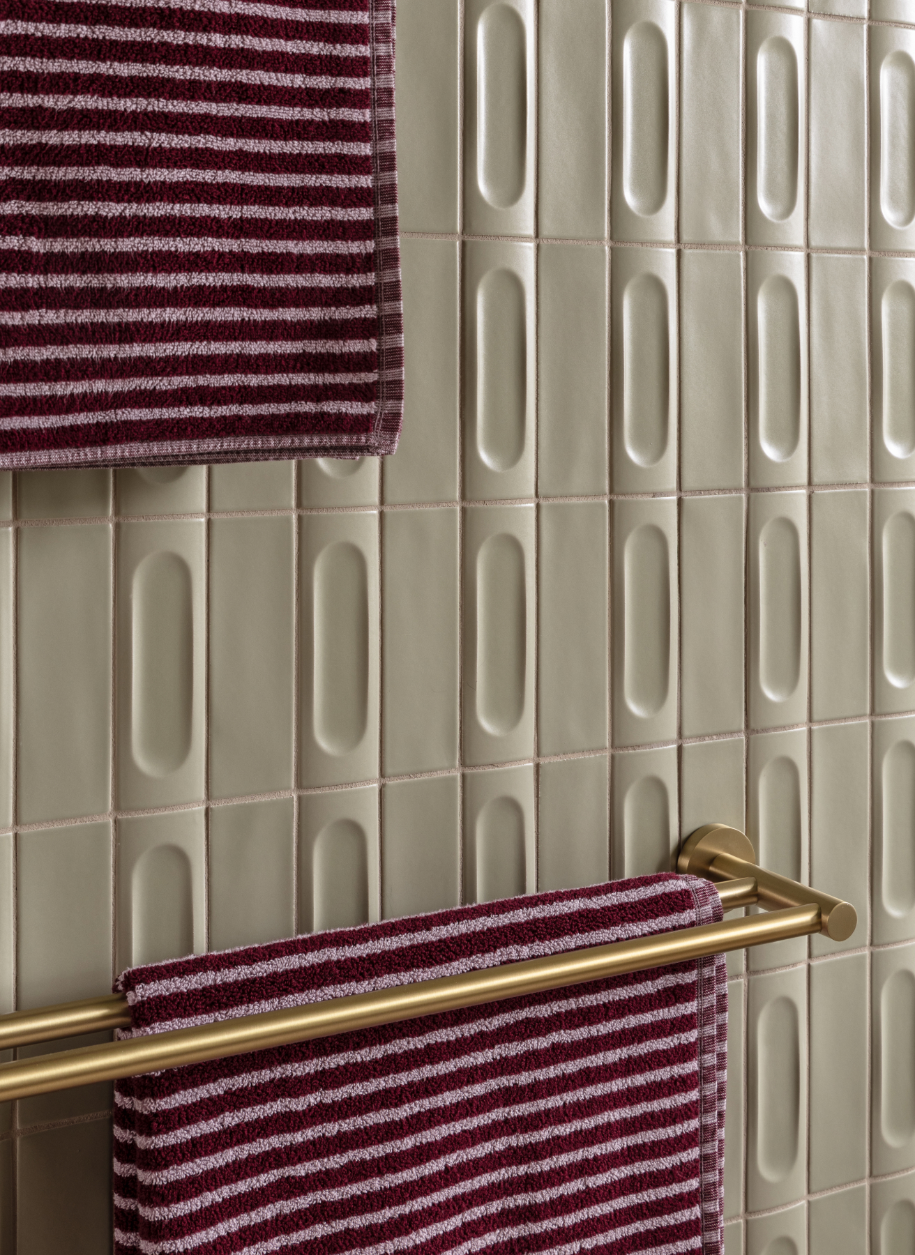 Green masonry in bathroom with gold/brass towel rail