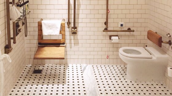 White accessible bathroom with oak accents, by Fitzroy of London