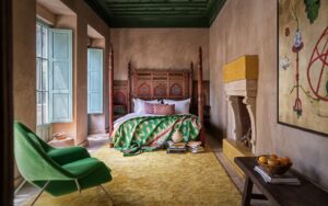 green chaair, yellow carpet and carved wooden bed in Jnane Rumi