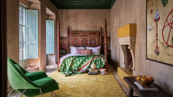 green chaair, yellow carpet and carved wooden bed in Jnane Rumi