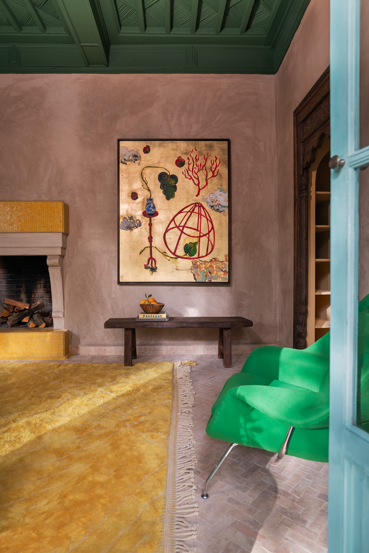 green ceiling, yellow carpet, green chair and art on wall