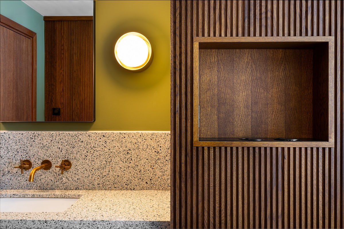 wood panelled wall leading into bathroom with terrazzo surfaces