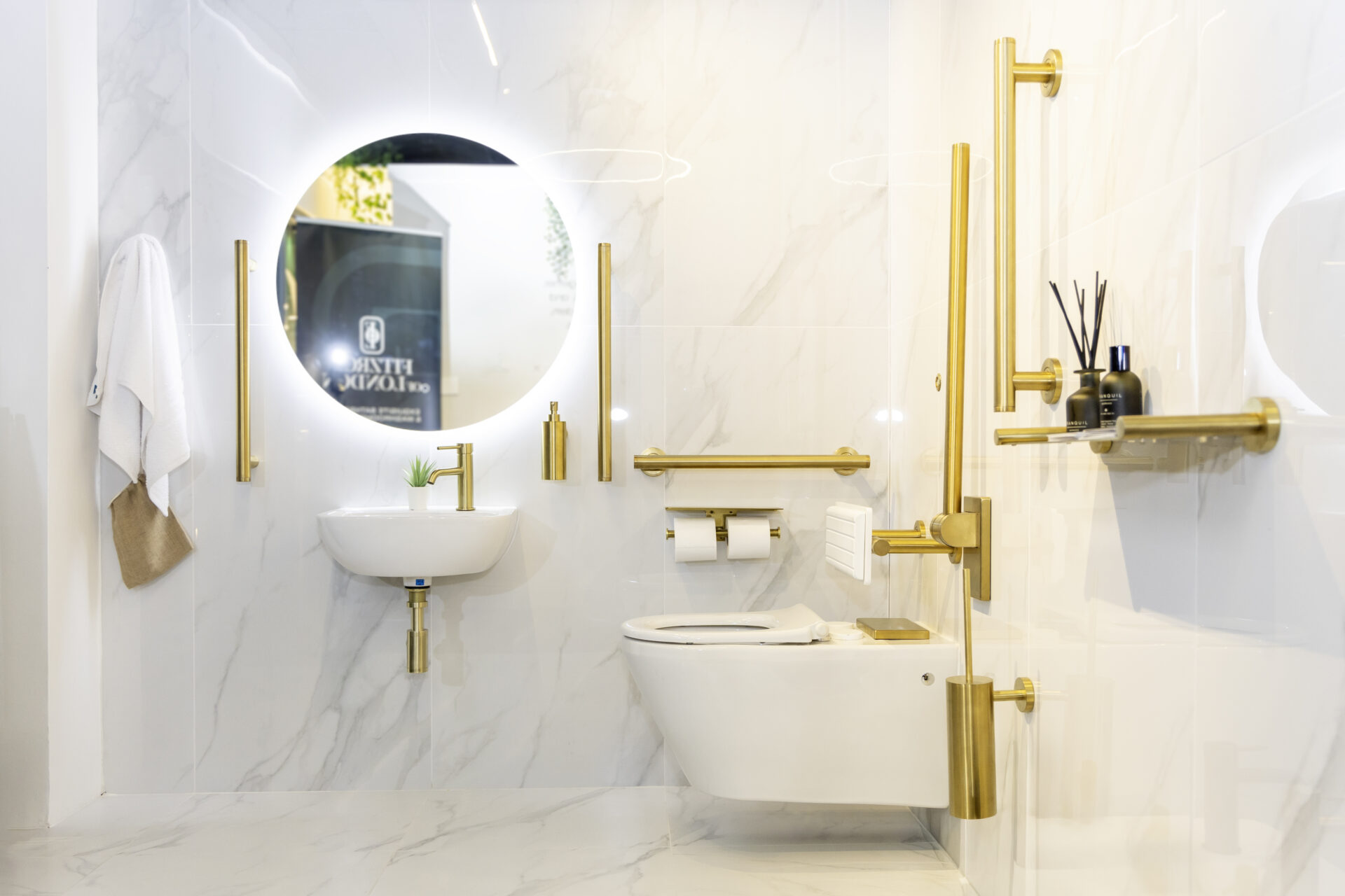 White marble and brass accent accessible bathroom by Fitzroy of London
