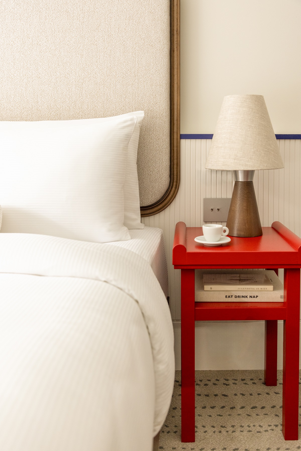 white bed detail, cream wall and red table