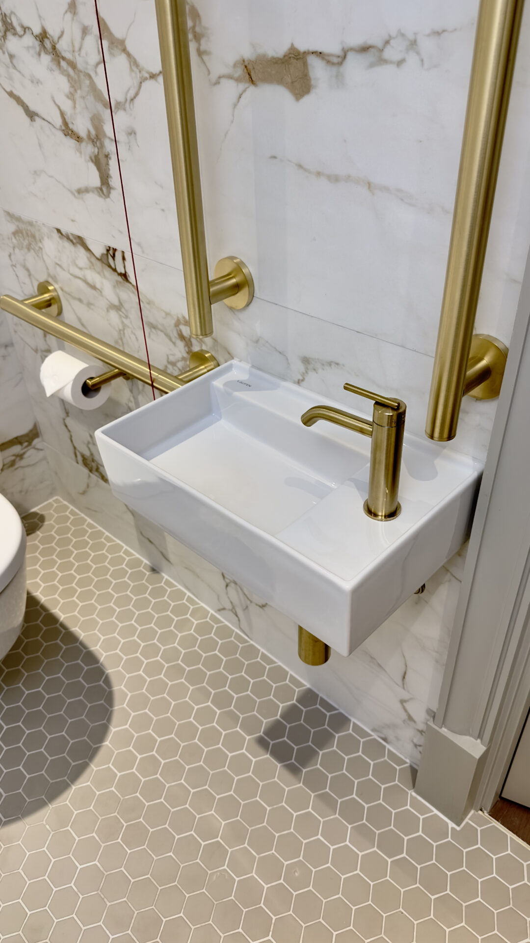 White marble and brass fixture bathroom at Montcalm Mayfair, by Fitzroy of London x Studio Mica