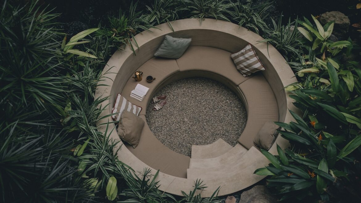 circular outdoor seating pit surrounded by tropical plants at Mantra Hotel in Mexico