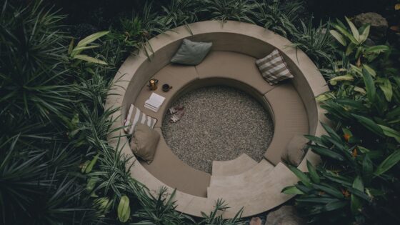 circular outdoor seating pit surrounded by tropical plants at Mantra Hotel in Mexico