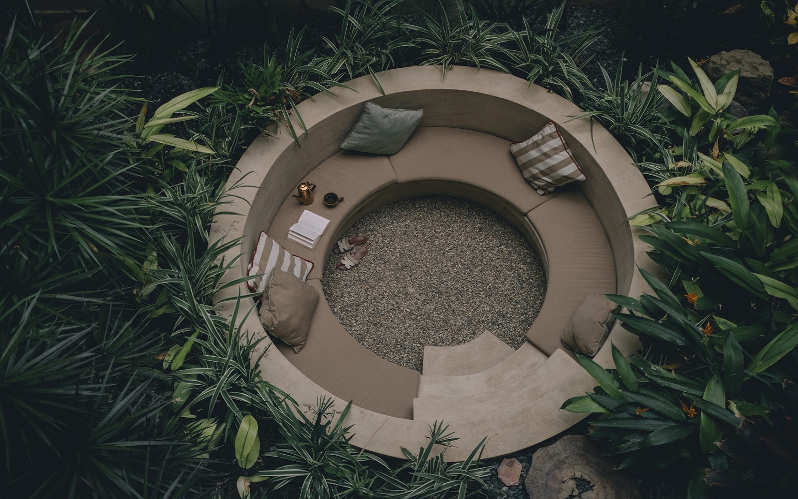 circular outdoor seating pit surrounded by tropical plants at Mantra Hotel in Mexico