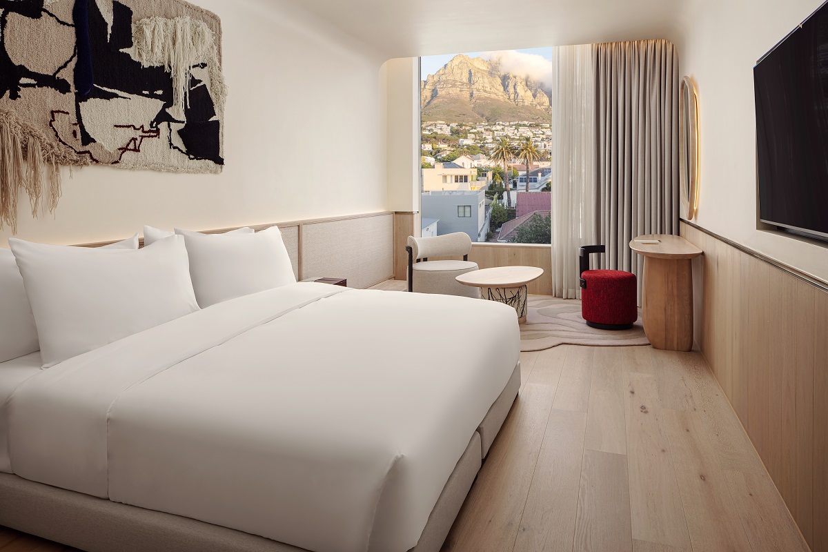 white and cream guestroom interior with tapestry on the wall and views over seven apostles mountains