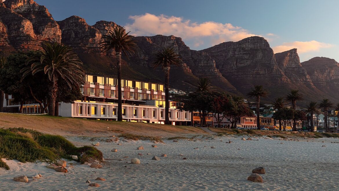 Morea House exterior with Camps Bay beach in front and mountains behind