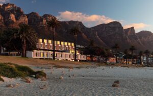 Morea House exterior with Camps Bay beach in front and mountains behind