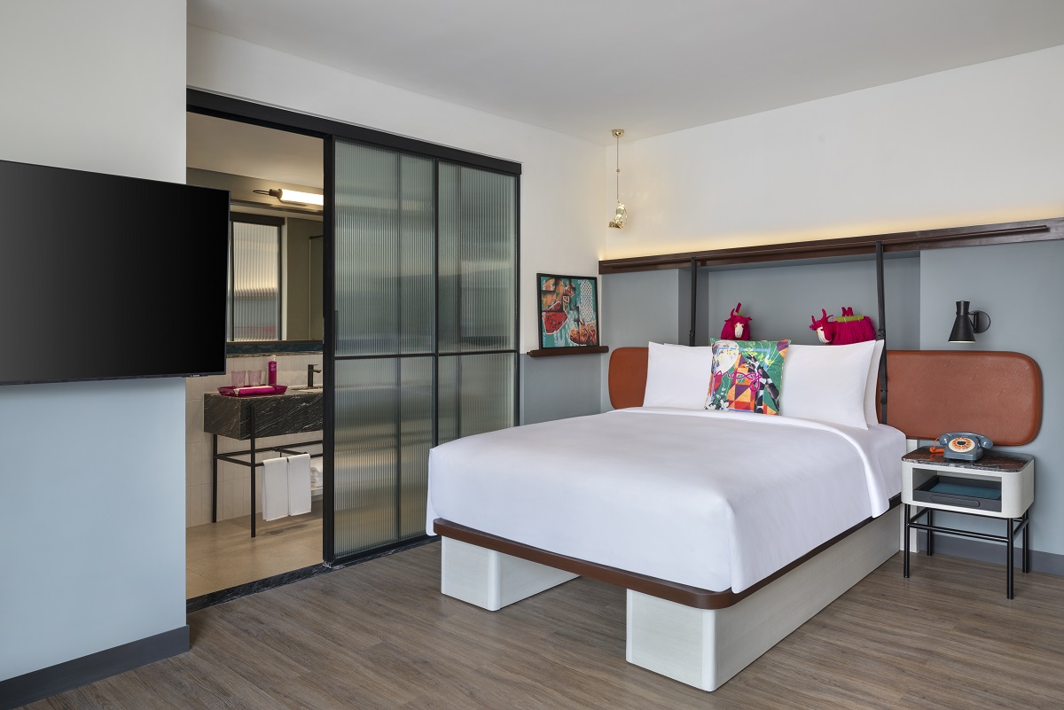 moxy guestroom with bed on square base and playful design elements on shelves