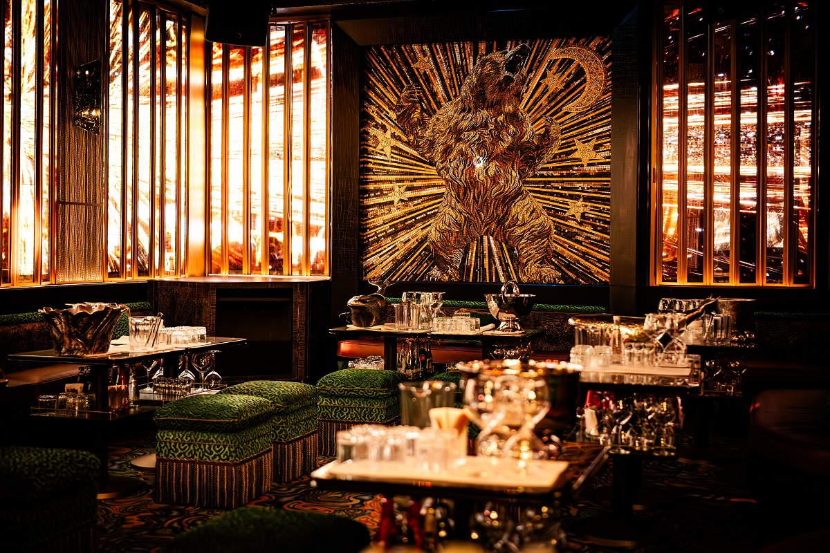 restuarant in L'Aventure PAris with mosaic bear on wall, velvet chairs and art deco details