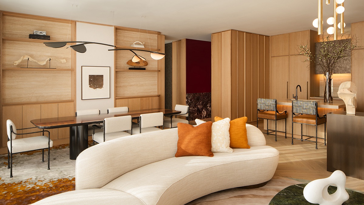 curved white couch in front of wooden dining table in hotel penthouse suite