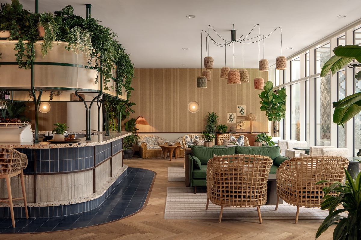 Daydreamer Cafe Paseo Austen cafe with curved bar topped with plants and wicker seating