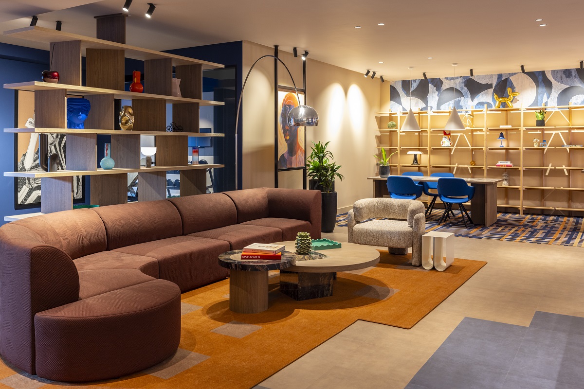 curved couch and colour-blocked carpet in lobby of TRIBE Den Haag
