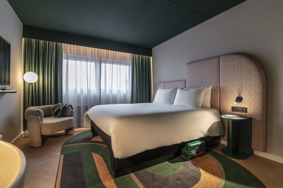 guestroom in TRIBE hotel with curved headboard reflecting carpet design
