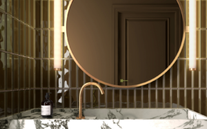 Round mirror by Luma Mirros on green tiled bathroom wall