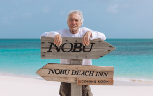 Robert De Niro behind sign for upcoming Nobu Beach Inn