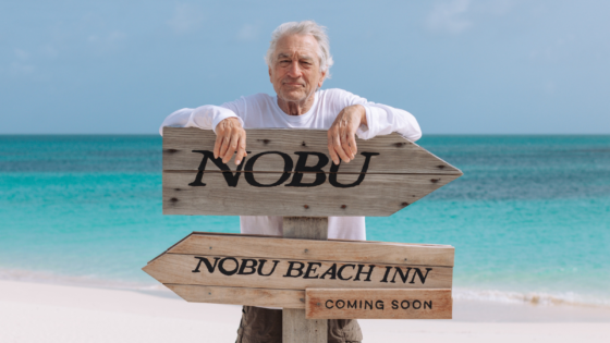 Robert De Niro behind sign for upcoming Nobu Beach Inn