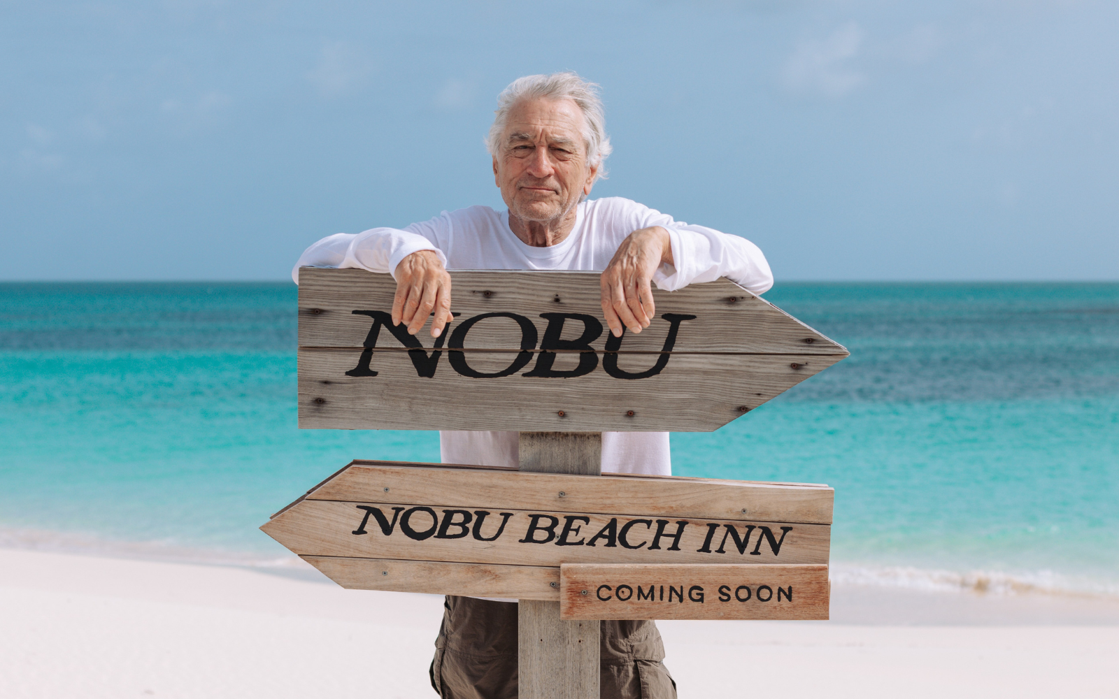 Robert De Niro behind sign for upcoming Nobu Beach Inn